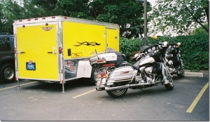 parked yellow covered trailer and Harley Davidson motorcycle