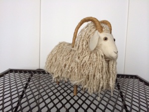 soft sculpture of goat with white locks and horns